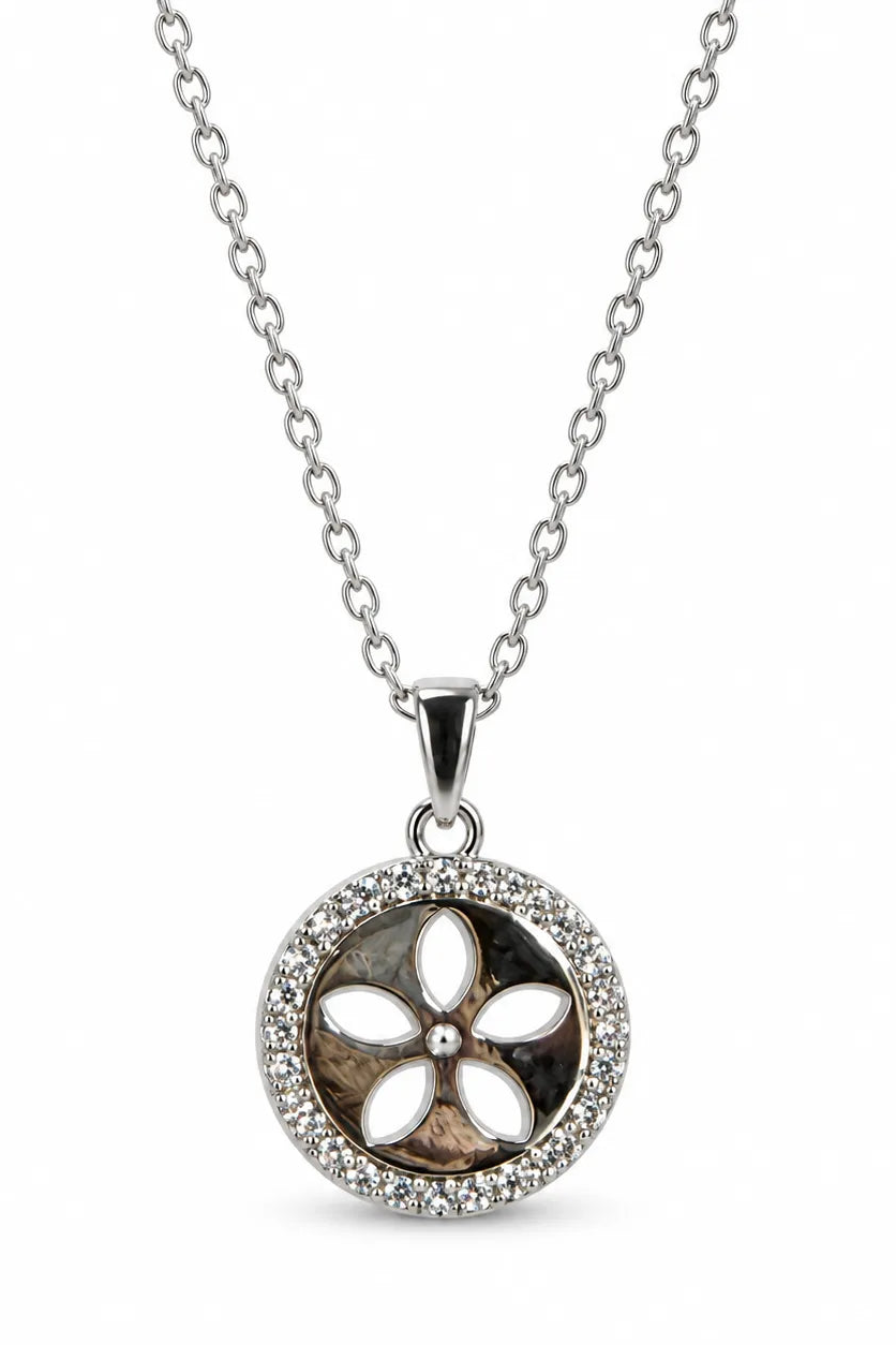 A silver chain necklace with a round pendant featuring a floral design. The center of the pendant is filled with a brown and black marbled pattern, surrounded by white inlay petals and a halo of small clear stones.